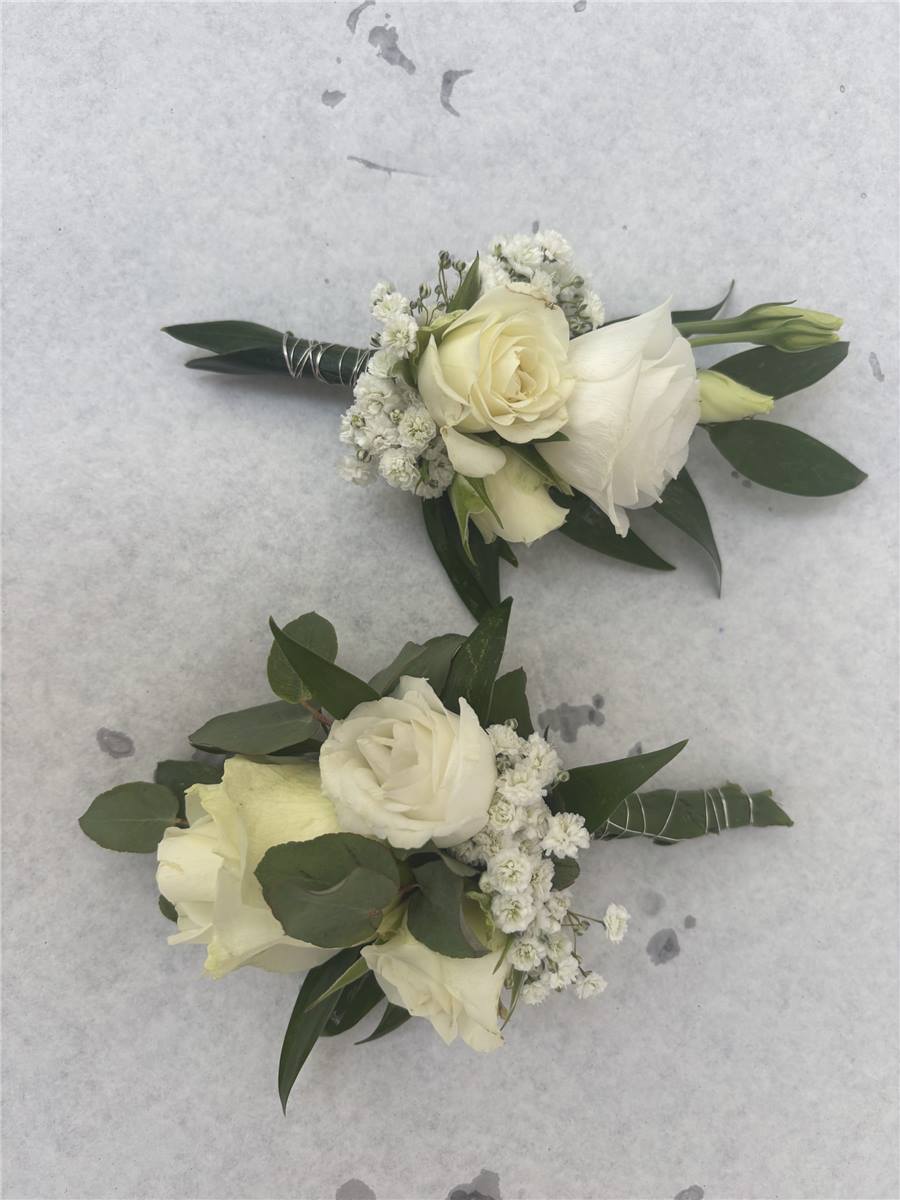 Zwei Anstecker mit weißen Rosen