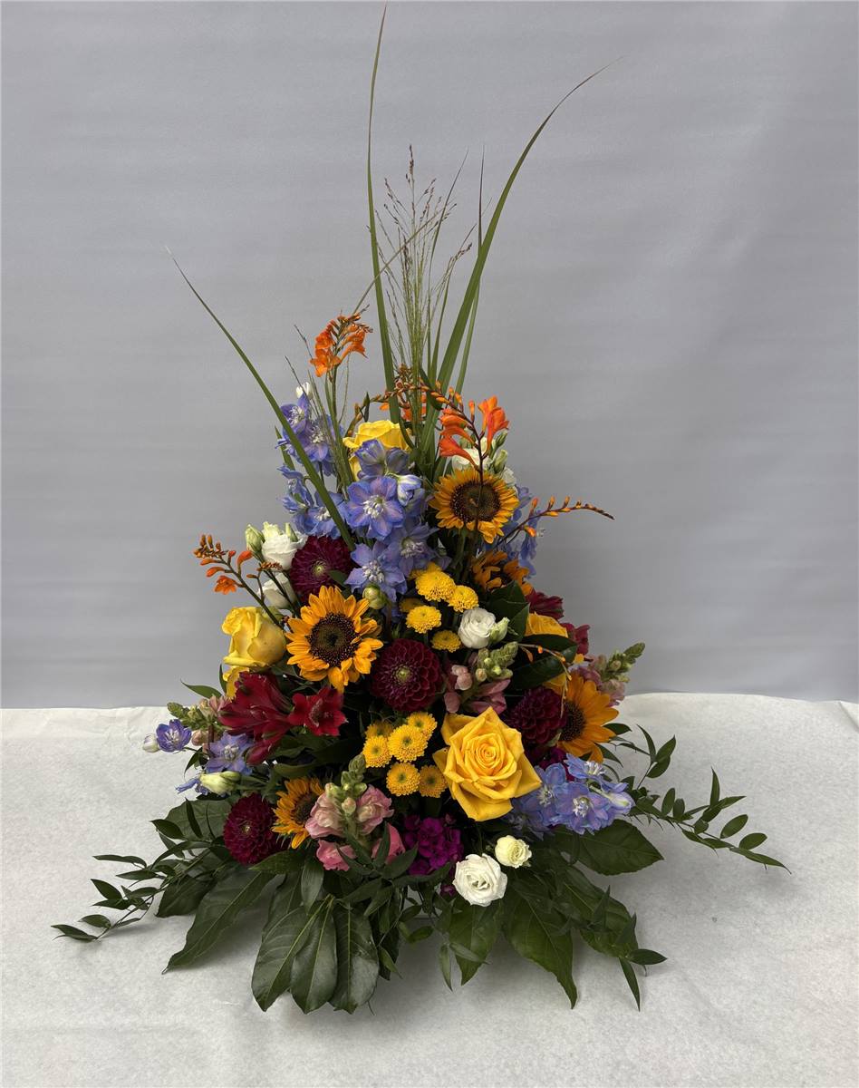 Hohes Trauergesteck mit Sonnenblumen und Rosen